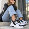 Mujer con Nike Air Max Bolt blancas y negras en outfit casual