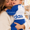 Madre con bebé en brazos llevando conjunto adidas azul y blanco talla 62