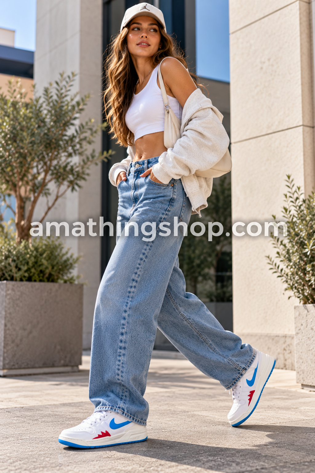Mujer caminando con zapatillas blancas estilo Jordan Stadium 90, Swoosh azul y detalles rojos, combinadas con vaqueros anchos en un look urbano.