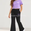 Niña con pantalón Nike Sportswear Trend Fleece negro de pernera acampanada y logotipo violeta, modelo DV2564-045