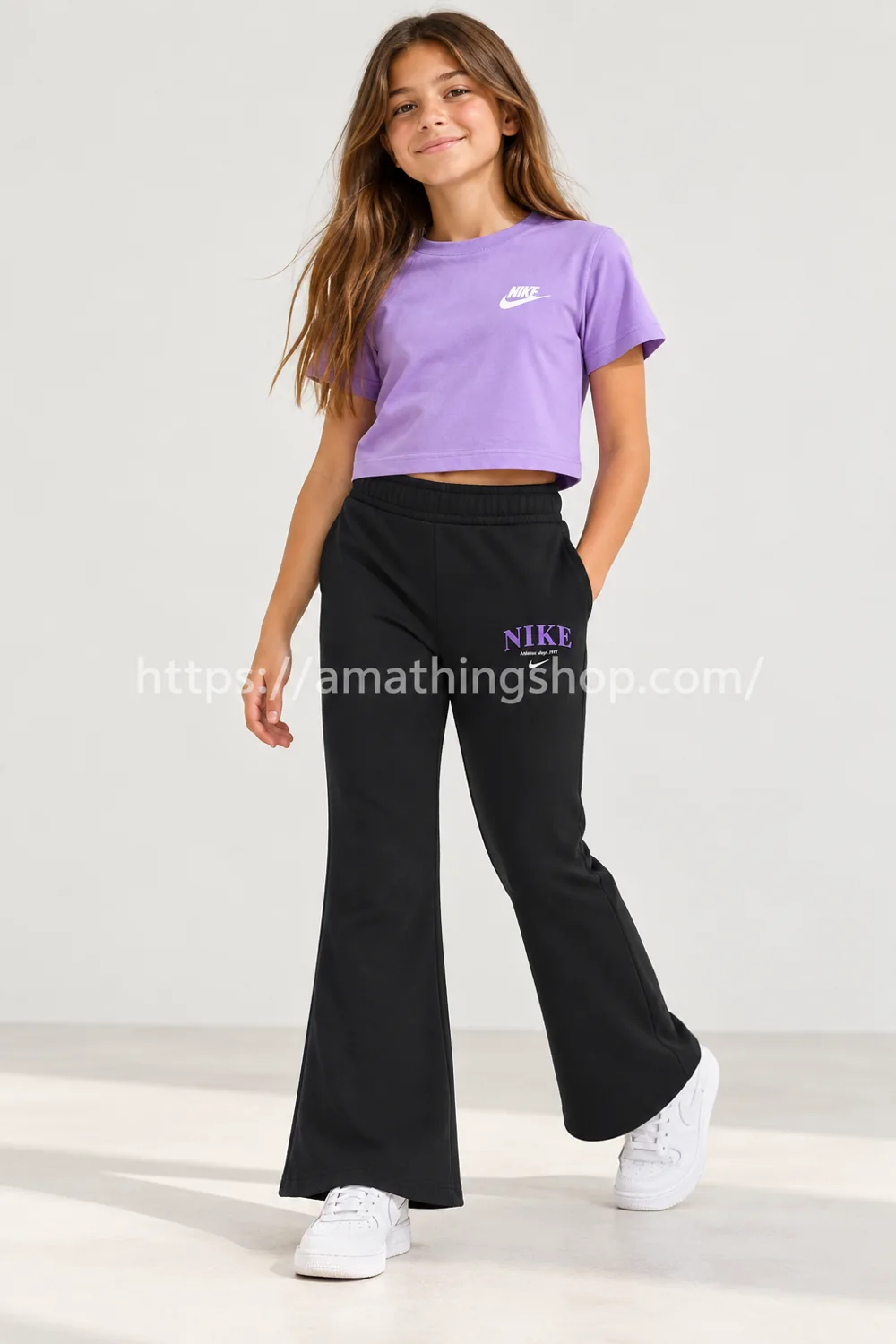 Niña con pantalón Nike Sportswear Trend Fleece negro de pernera acampanada y logotipo violeta, modelo DV2564-045