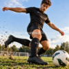 Futbolista con botas negras Nike Phantom GX II Academy SG-Pro AC realizando un disparo sobre césped natural.